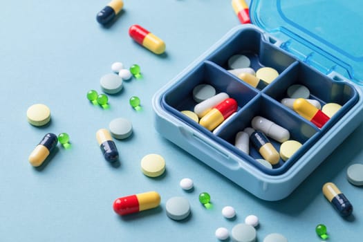 composition with pill box and pills on blue color background