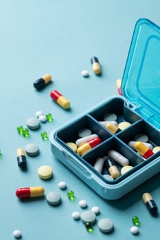 composition with pill box and pills on blue color background