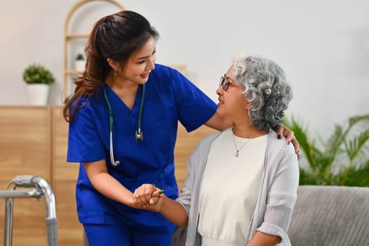 Caring healthcare worker talking while visiting senior woman patient at home. Healthcare concept