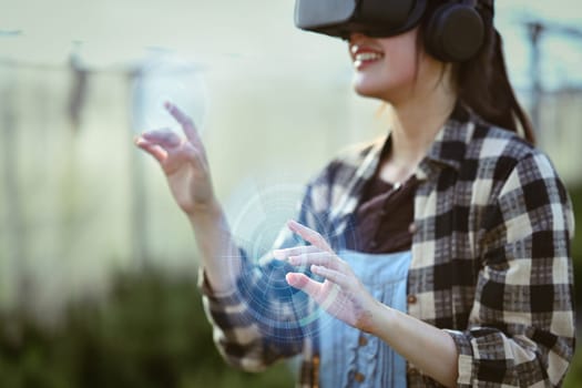 Farmer wearing VR headset for controlling process in greenhouse cultivation. Modern and smart agriculture concept