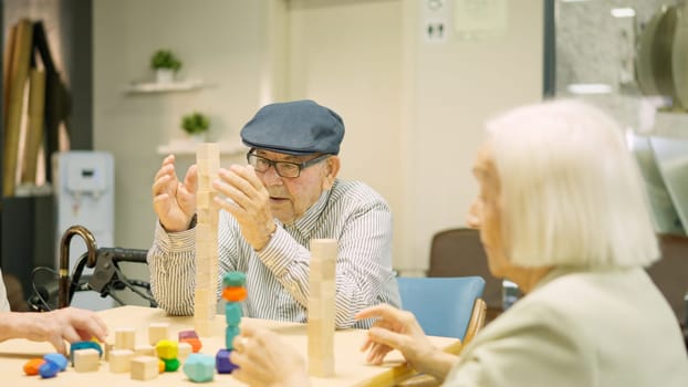 Man building a wooden tower as skill games in a geriatric