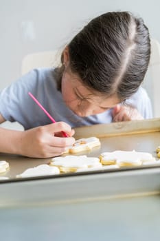 A heartwarming scene of a little girl carefully writing 'Sorry' on sugar cookies with food coloring, the cookies beautifully flooded with white royal icing.