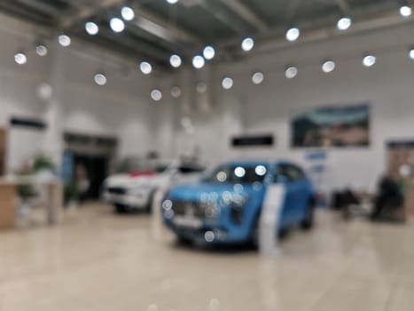 Blurred new car parked in modern showroom waiting for sales. Abstract background of blurred new cars dealership place.