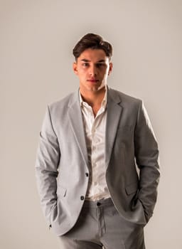 Attractive elegant young man with business suit, on white, looking at camera