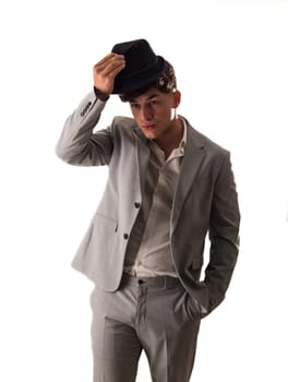 Attractive elegant young man with business suit and fedora hat, isolated on white, looking away, seen sideways