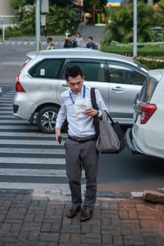 Jakarta, Indonesia - October 4 2023: Busy Businessman: Eating and Multitasking