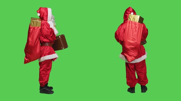 Saint nick with bag of presents and briefcase, looking for transportation to deliver gifts to kids around the globe. Young person portraying santa claus with vintage suitcase and red sack.