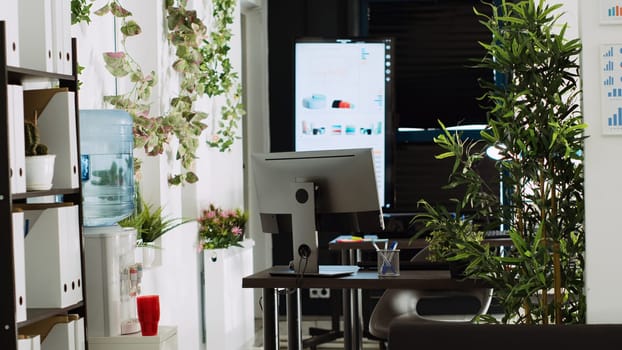 Startup company open space with work desks and tools used for small business executive tasks in sales department. Empty company coworking space, boardroom decorations and supplies.