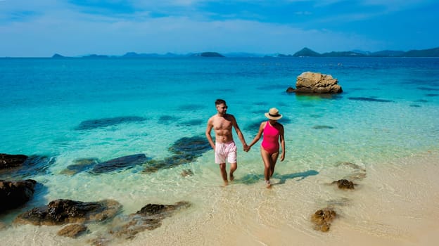 A couple of European men and Asian woman on a boat trip at Ko Kham Island Sattahip Chonburi Samaesan Thailand