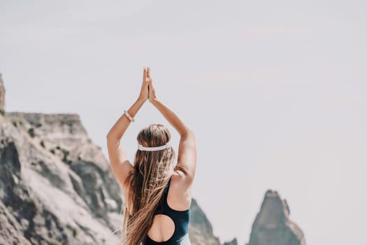 Woman beach vacation photo. A happy tourist in a blue bikini enjoying the scenic view of the sea and volcanic mountains while taking pictures to capture the memories of her travel adventure