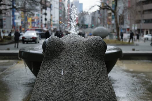 View of a frog water fountain from behind.