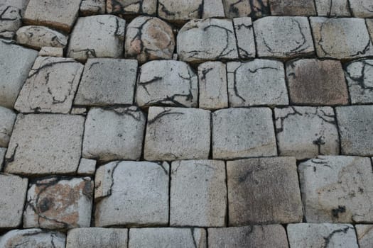Old wall Old cobblestone with various shapes and sizes of stones, suitable for backgrounds and patterns.