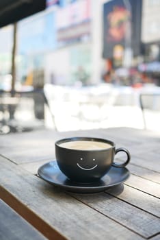 black coffee cup with smile shape design on it .