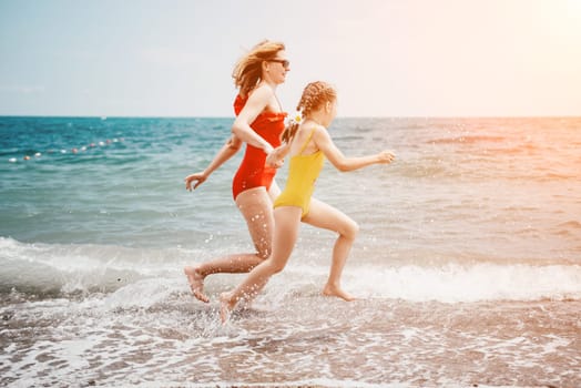 Happy loving family mother and daughter having fun together on the beach. Mum playing with her kid in holiday vacation next to the ocean - Family lifestyle and love concept.