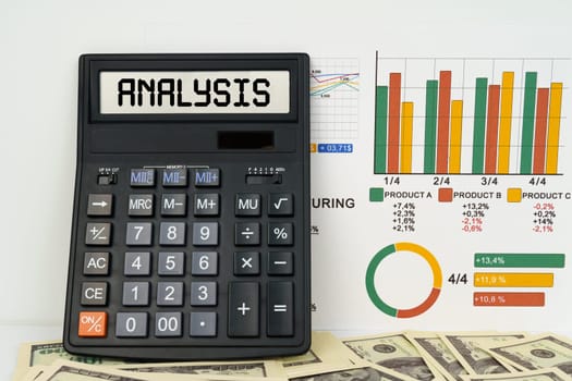 Business concept. On the table are financial reports, dollars and a calculator with the inscription - ANALYSIS