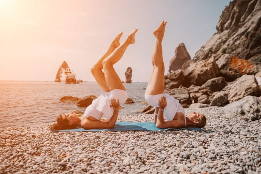 Woman sea yoga. Back view of free calm happy satisfied woman with long hair standing on top rock with yoga position against of sky by the sea. Healthy lifestyle outdoors in nature, fitness concept.