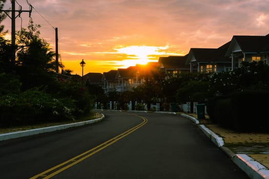 Modern cottages row road sidewalk two story buildings residential villas village New Estate Reflection dawn Sun in windows.