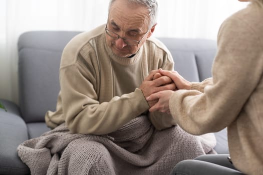 Head shot old male pensioner involved in rehabilitation procedure with caring young physiotherapist. retired man with walking disability feeling thankful for professional help