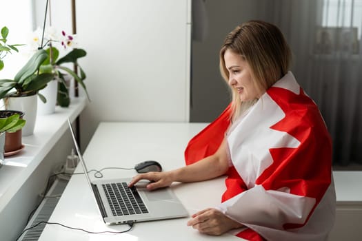 woman hands and flag of Canada on computer, laptop keyboard . High quality photo