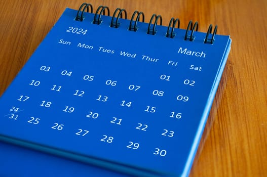 March 2024 table calendar on wooden desk. Time and calendar concept.