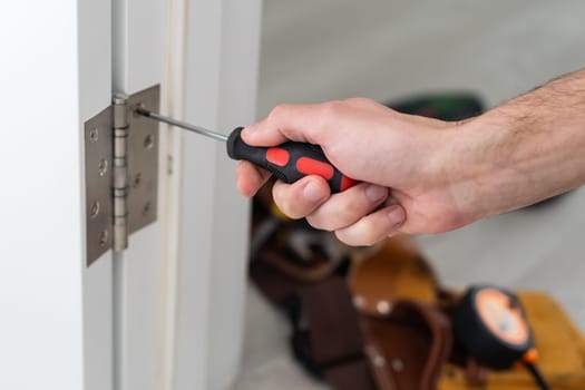 A handyman repair the door lock in the room. The concept repair yourself. Selective focus. High quality photo