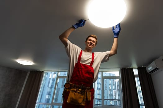 An electrician is installing LED spotlights on the ceiling