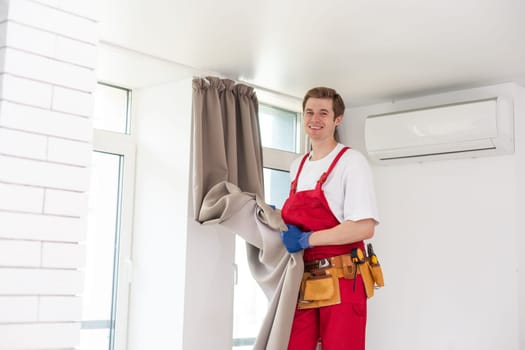 A male worker who installs a curtain