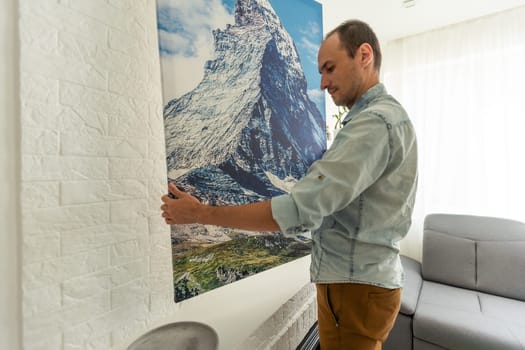 man holds photo canvas at home. High quality photo