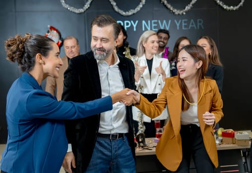 Asian business woman shake hands to her colleague after get the present or gift from new year party of the company.