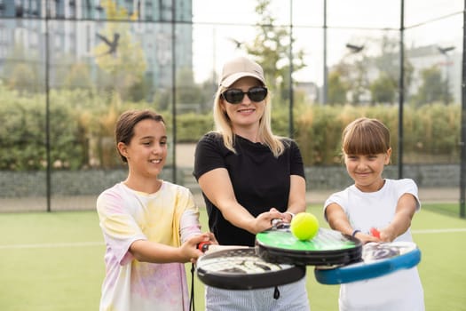 mother and daughters playing padel outdoor. High quality photo