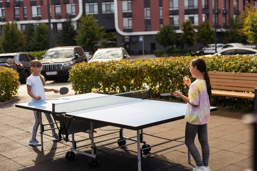 little girl playing table tennis in the tennis hall, tennis racket hitting the ball, the pitch of the ball. High quality photo