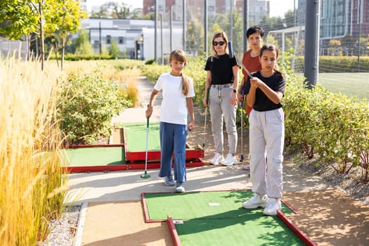 Kids playing golf inside playground artificial grass activity game for children . High quality photo