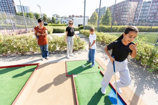 family playing mini golf on a cruise liner. Child having fun with active leisure on vacations. High quality photo