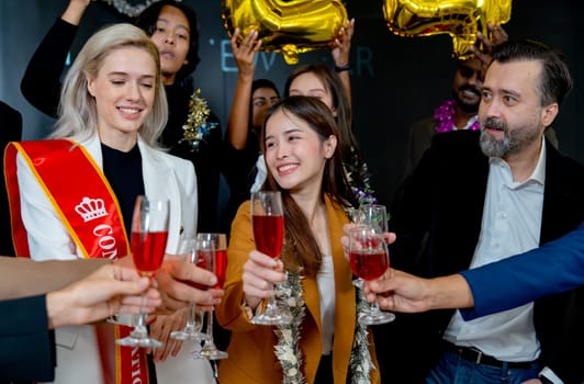 Asian business woman enjoy to cheers with wine glass together with the manager and other coworkers during party in the office.