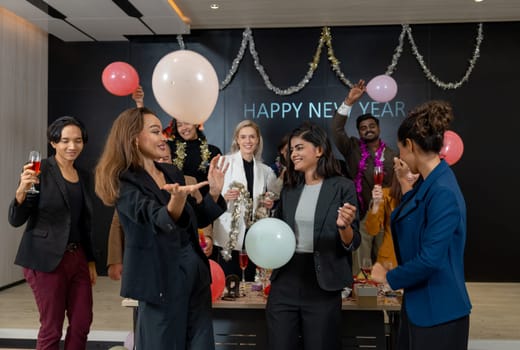 Business men and women hold balloon with multiethnic enjoy to dance in new year party with balloon in hall room.