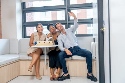 Business man and women enjoy break time also selfie together in the office before have lunch with the pizza.