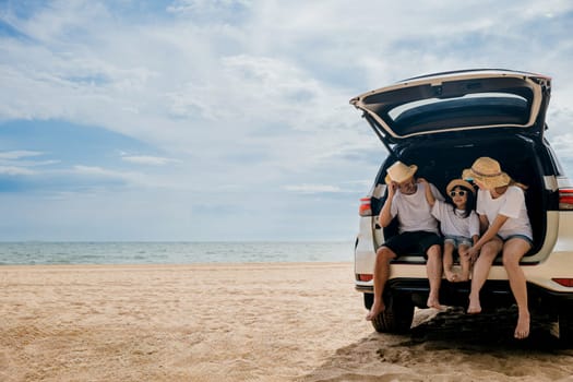 People enjoying road trip sitting down on back their car, Parents and children traveling in holiday at sea beach, family fun in summer vacation on beach blue sky, Happy Family and World Tourism Day