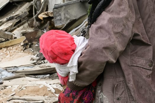 Mother and children near a destroyed house