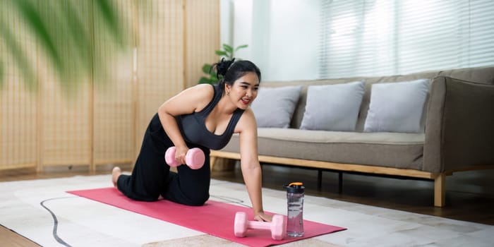 Cheerful attractive young overweight woman in activewear choosing healthy lifestyle.