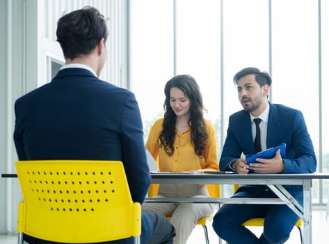 Job interview concept. Diverse hr team doing job interview with a man in business office. Human resources team interviewing a potential job candidate. Hiring, employment, and recruitment concept.