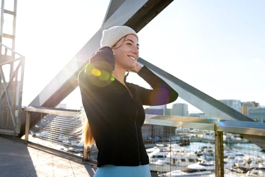 Portrait of happy young fitness woman wearing sports clothing outdoors in winter time. Active lifestyle concept.