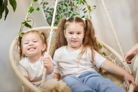 Happy time concept. Girls Sisters in chair and having fun. Female Preschooler and teenager playing and relaxing in room