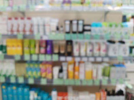 Blurred background with shelves with skin and hair care products in a cosmetic store. Rack with shelves with cosmetics in a store.