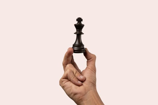 Black male hand holding a queen chess figure isolated. High quality photo