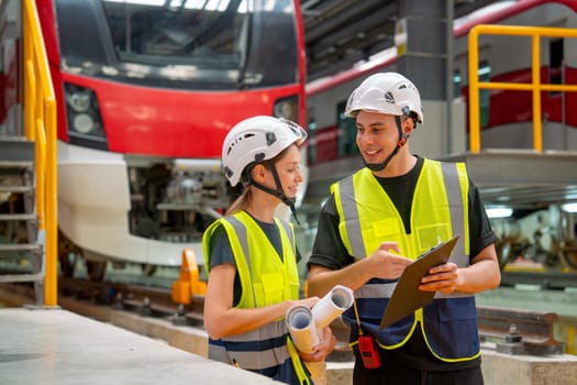 Technician worker or engineer man try to explain the data on paper that he carry to his co-worker woman and stay in front of factory workplace or maintenance center.