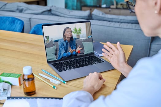 Close-up of young woman patient in laptop screen having video online counseling therapy with female doctor. Medicine, technology, internet service, treatment, physical and mental health