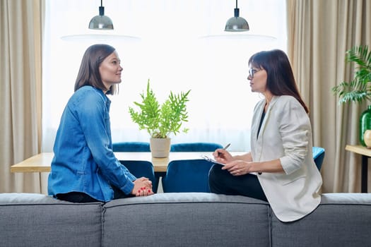 Happy joyful young woman patient talking to female psychologist counselor at therapy session. Positive treatment results, mental health of youth. Psychology psychotherapy support help rehabilitation