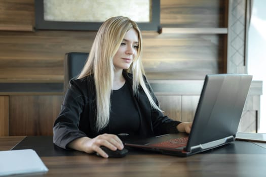 Young teacher is sitting in front of laptop conducting lesson, concept of online teaching.