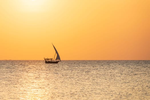 Summer concept, dhow boat sails in the ocean at sunset, Zanzibar, Tanzania.