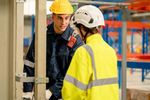 Professional engineer man teach or guide process to control or work with the machine to co-worker woman in workplace area.